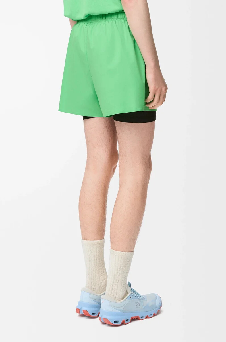 performance-shorts aus technischem shellmaterial in grün
